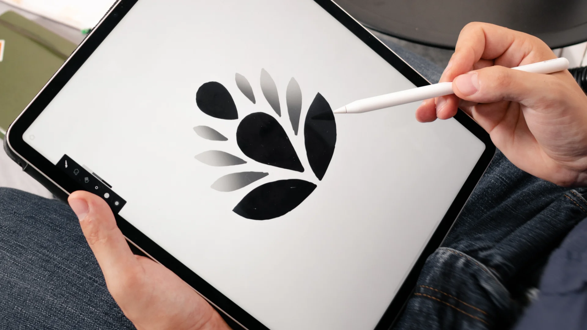 A designer drawing a brand mark on a tablet with a stylus