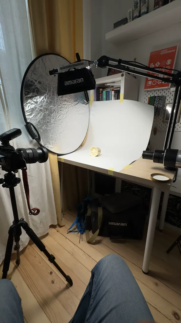A photo studio set up with a reflector, light and tripod for product shots