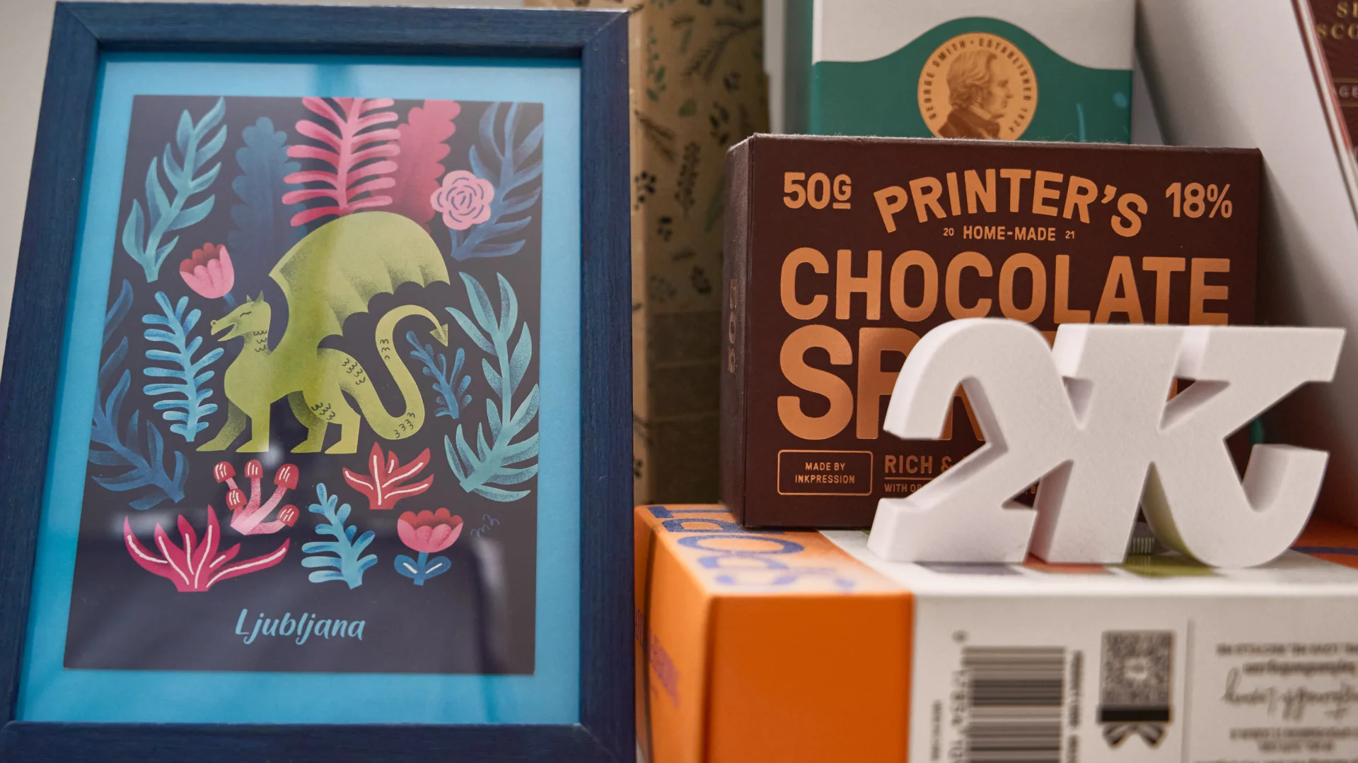 A framed dragon illustration, a chocolate bar pack and 3D letters in the Embrand studio