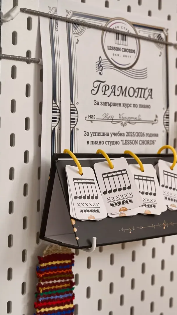 A printed certificate and chord cards for Lesson Chords on a pegboard