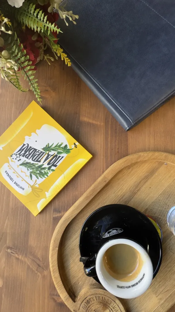 A cup of coffee and a packet of tea on a wooden table before a conversation